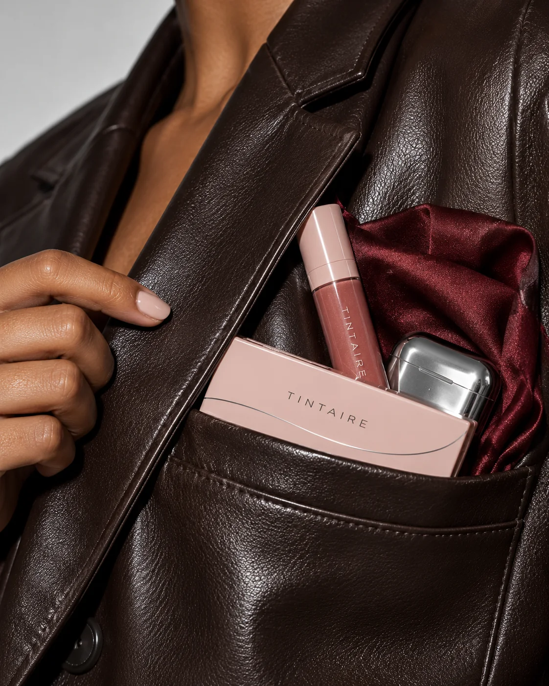 TINTAIRE palette and lip product styled in a leather jacket pocket
