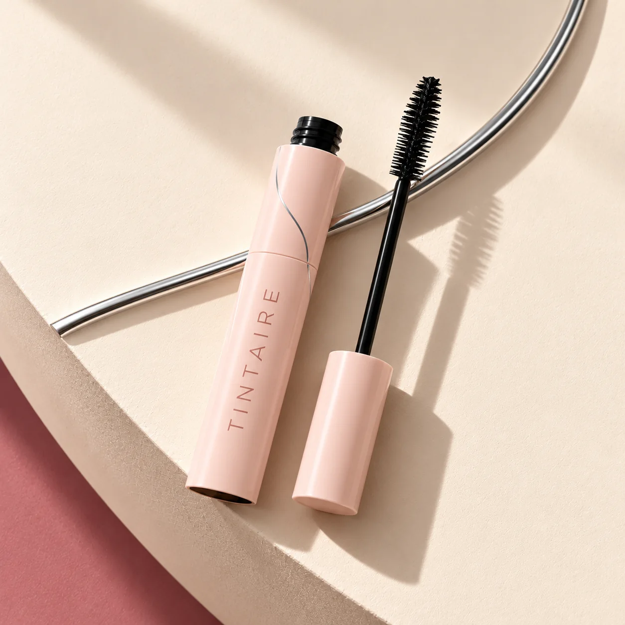 Open TINTAIRE mascara and wand in a modern editorial product study